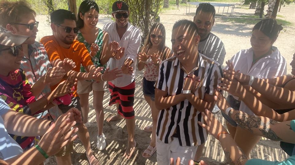 Participantes en círculo durante una dinámica al aire libre