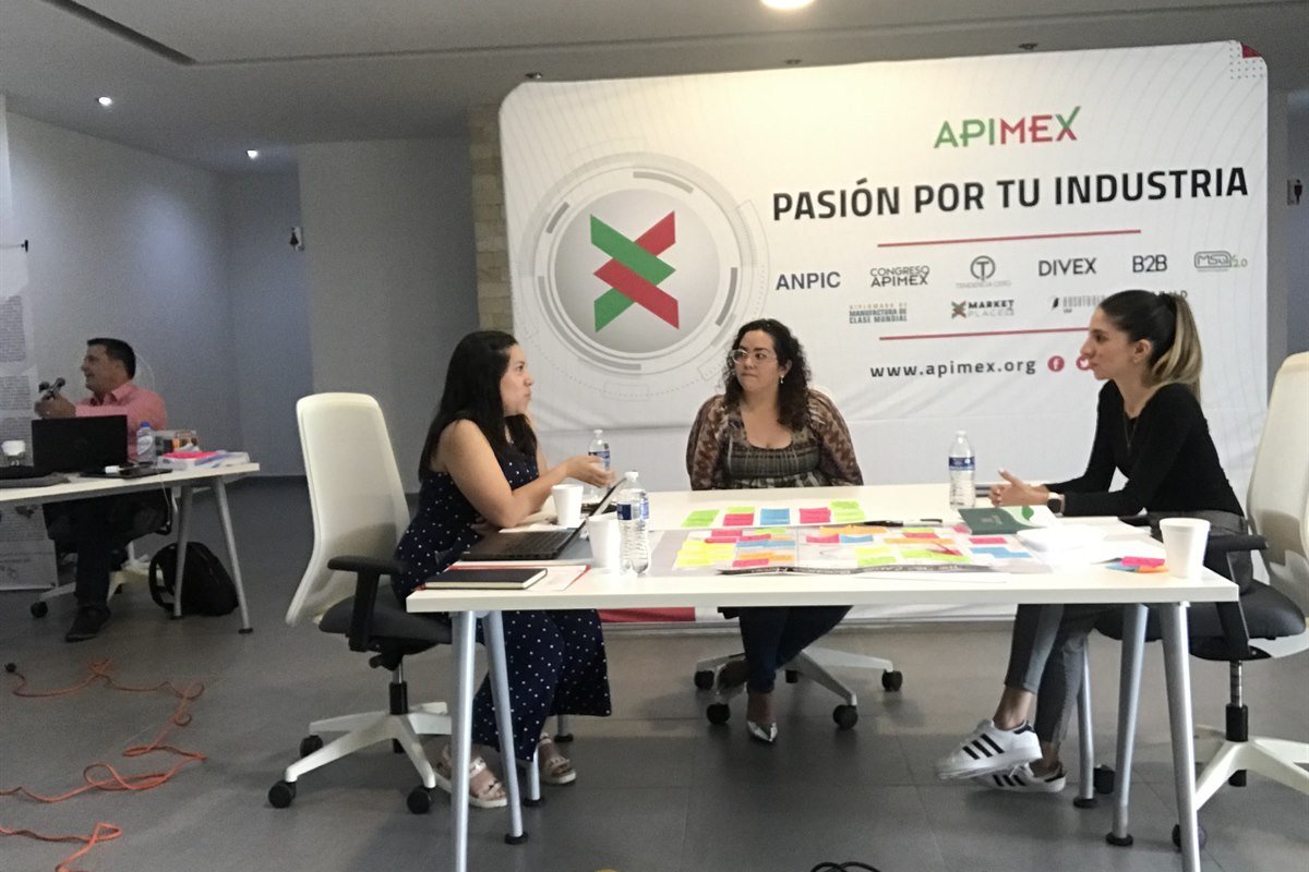 Equipo en un taller de AUKER trabajando sobre una mesa con notas de colores